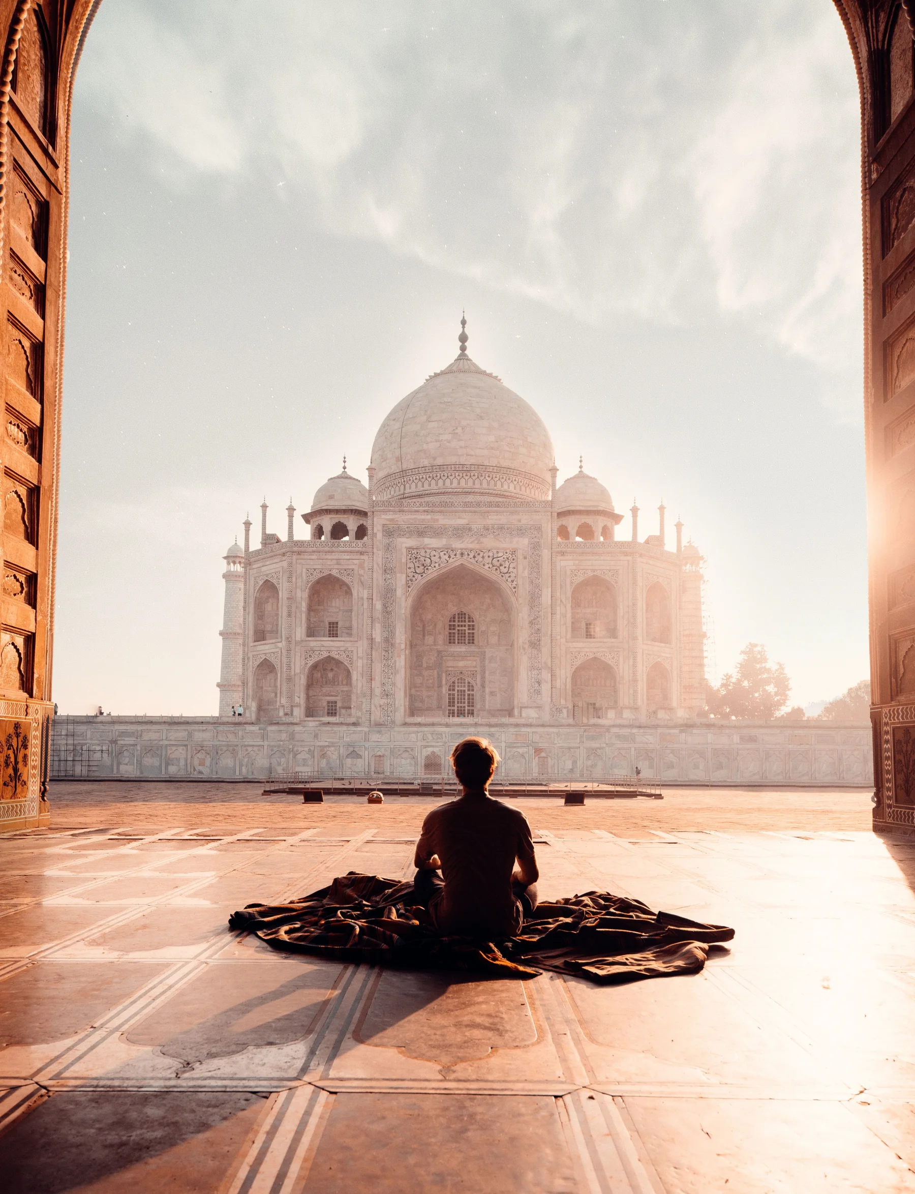Traveller facing the Taj Mahal at sunrise